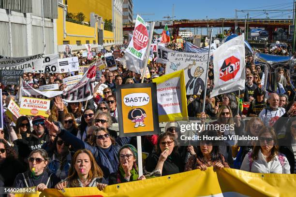 Teachers hold protest signs as they march from the Ministry of Education to Belem Presidential Palace to protest for better working conditions during...