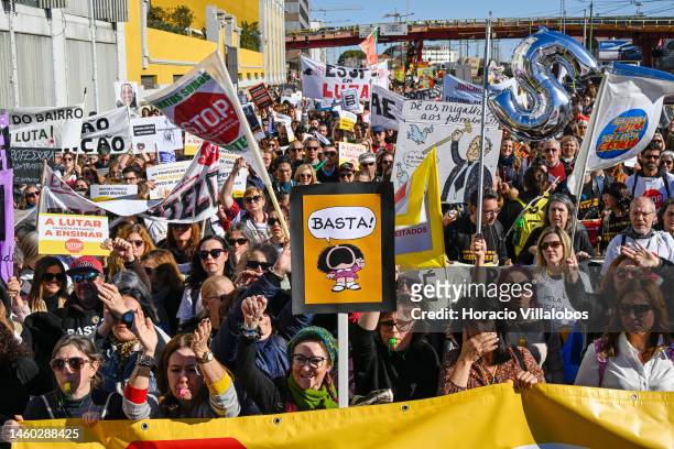 Teachers hold protest signs as they march from the Ministry of Education to Belem Presidential Palace to protest for better working conditions during...