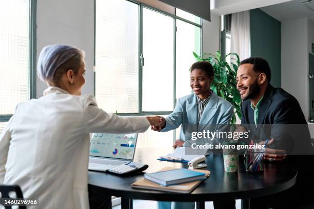 businesswoman closing a deal with clients - consultor financeiro imagens e fotografias de stock