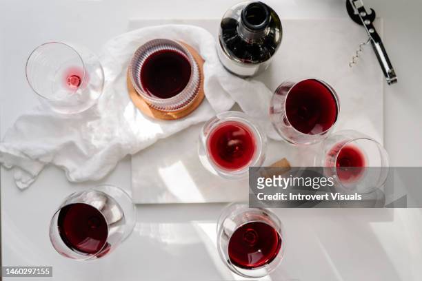 several red wine glasses on the white marble table and a bottle - white wine overhead stock pictures, royalty-free photos & images