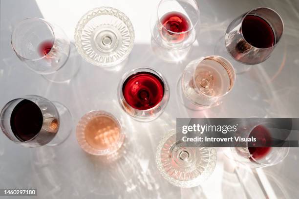 glasses of red white rose wine and wine bottle on the table shot from above - red wine glass stockfoto's en -beelden