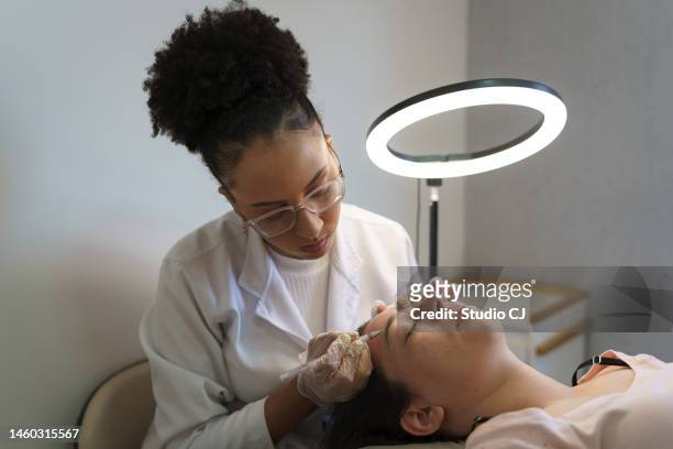 eyebrow design performing procedure on client - satisfação stock pictures, royalty-free photos & images