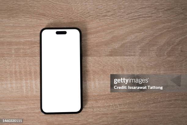 smartphone on wooden table on light background - oberteil stock-fotos und bilder