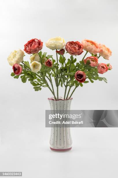 artificial ranunculus flowers in vase on wihte background - imitatie stockfoto's en -beelden