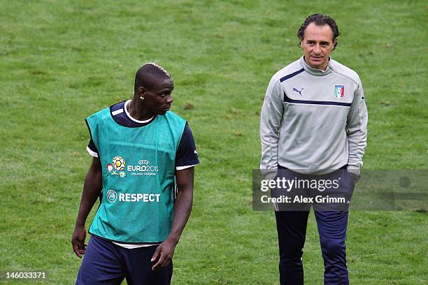 Mario Balotelli of Italy walks past head coach Cesare Prandelli during a UEFA EURO 2012 training session ahead of their Group C match against Spain...