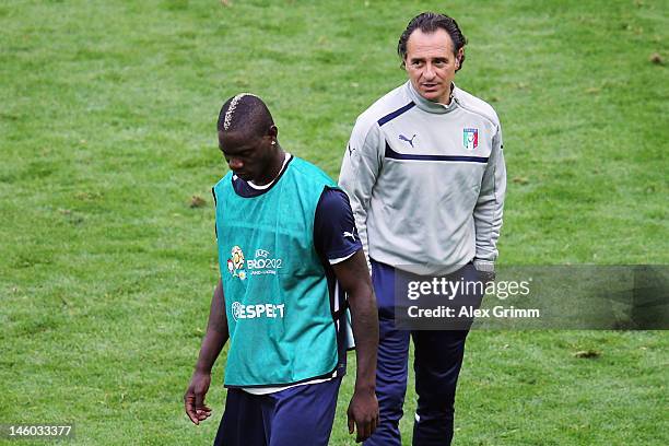 Mario Balotelli of Italy walks past head coach Cesare Prandelli during a UEFA EURO 2012 training session ahead of their Group C match against Spain...