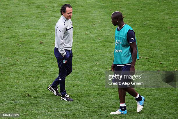 Mario Balotelli of Italy walks past head coach Cesare Prandelli during a UEFA EURO 2012 training session ahead of their Group C match against Spain...