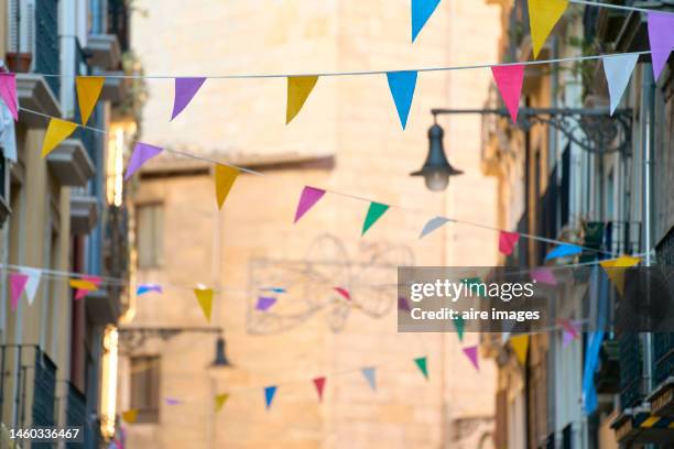 alley decorated with colorful banners in a row as part of a typical celebration of the city. - navarra - fotografias e filmes do acervo