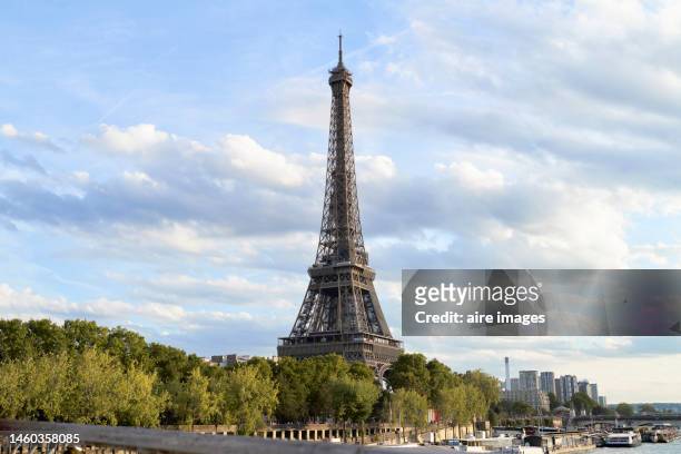 side view of the eiffel tower from a bridge over the seine river without people with a sunset in paris - eifel tower stock pictures, royalty-free photos & images