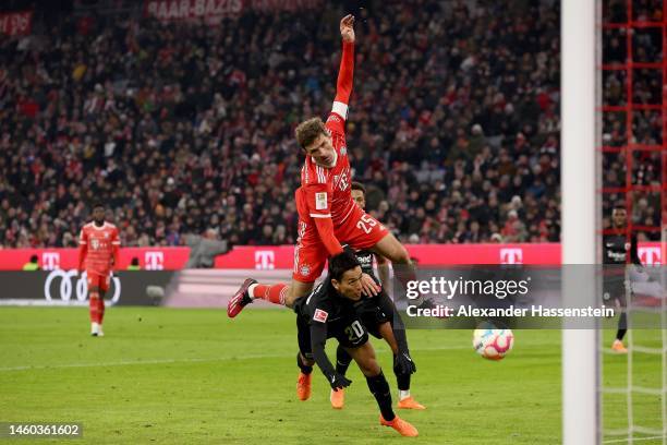 Thomas Mueller of Bayern Munich is tackled by Makoto Hasebe of Eintracht Frankfurt during the Bundesliga match between FC Bayern München and...