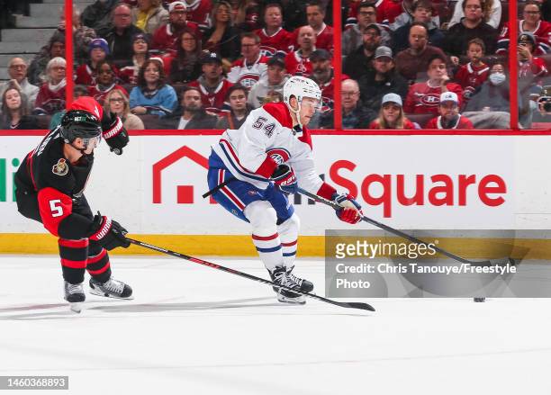 Jordan Harris oft he Montreal Canadiens skates with the puck against Nick Holden of the Ottawa Senators during the first period of the game at...
