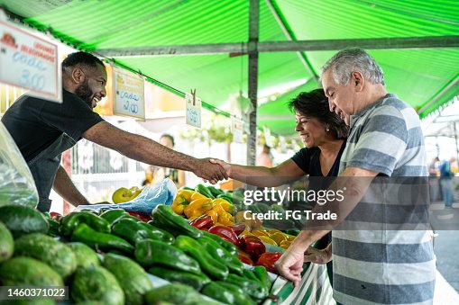 Salesman greeting customers on a street market Salesman greeting customers on a street market