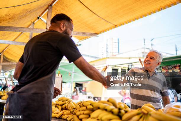 customer greeting the salesman on a street market - fresh deals stockfoto's en -beelden