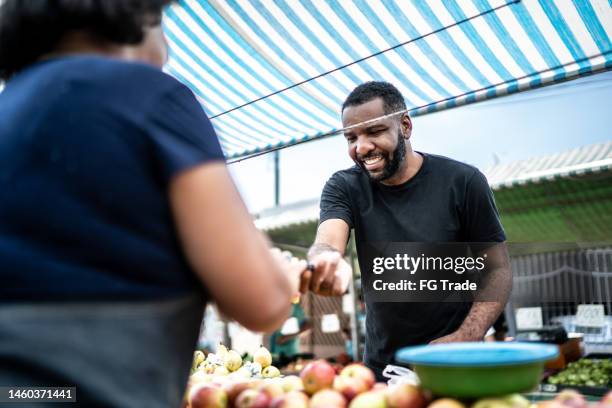 cliente pagando con tarjeta de crédito en un mercado callejero - apple credit card fotografías e imágenes de stock