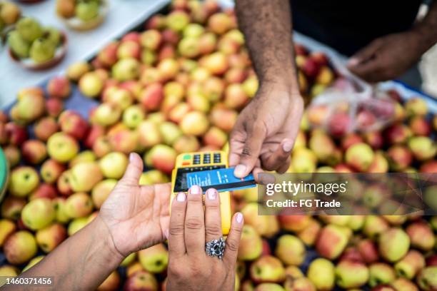 nahaufnahme menschlicher hände, die auf einem straßenmarkt mit kreditkarte bezahlen - markt verkaufsstätte stock-fotos und bilder