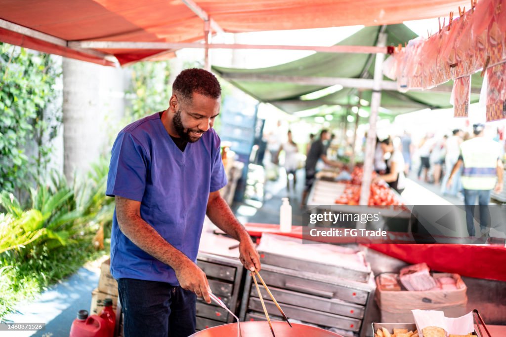 Salesman frying "Pasty" Fried (brazilian pastel) on a street market