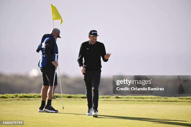 Keegan Bradley of the United States acknowledges the crowd after a putt on the 14th green during the final round of the Farmers Insurance Open on the...