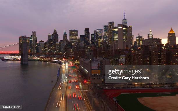 Traffic moves along FDR Drive as the sun sets behind lower Manhattan on January 28 in New York City.