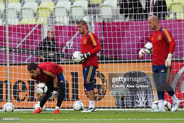 Goalkeeper Iker Casillas of Spain catches a ball ahead of Victor Valdes and Pepe Reina during a UEFA EURO 2012 training session ahead of their Group...
