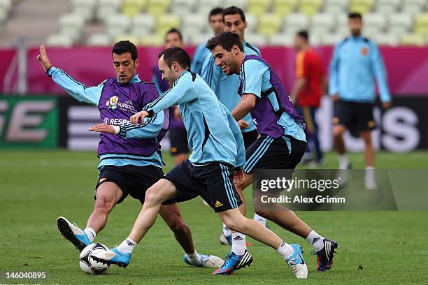 Andres Iniesta of Spain is challenged by Sergio Busquets and Javi Martinezduring a UEFA EURO 2012 training session ahead of their Group C match...