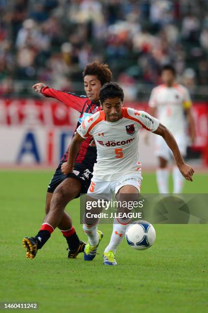 Carlinhos Paraiba of Omiya Ardija controls the ball against Yoshihiro Uchimura of Consadole Sapporo during the J.League J1 match between Consadole...