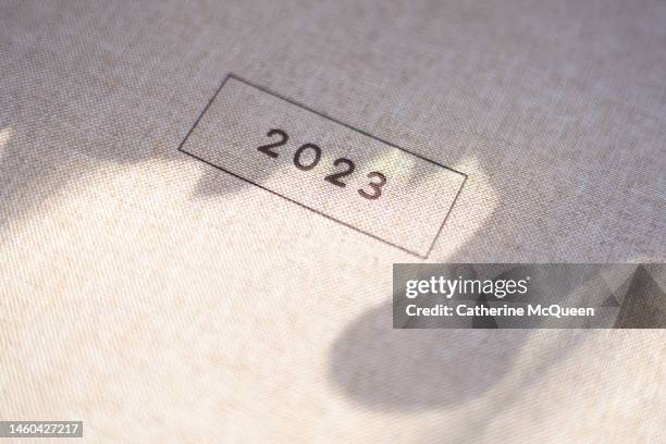 the year “2023” printed in a box on linen background - blue monday stock-fotos und bilder