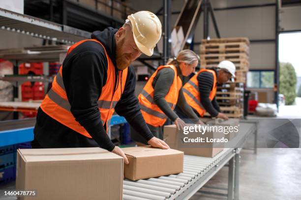 three warehouse workers on a packing and delivery production line - warehouse stock pictures, royalty-free photos & images