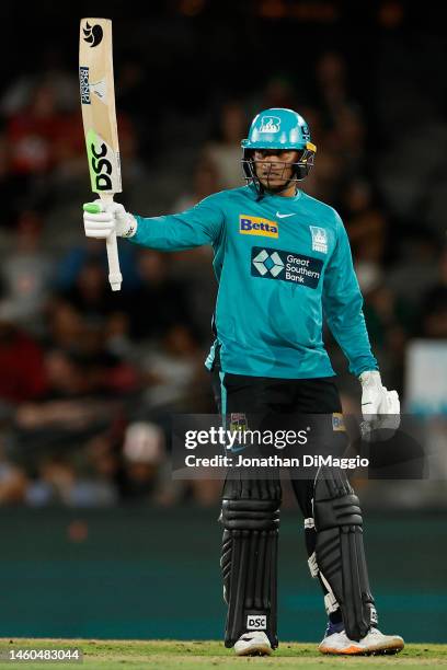 Usman Khawaja of the Heat celebrates after scoring half a century during the Men's Big Bash League match between the Melbourne Renegades and the...