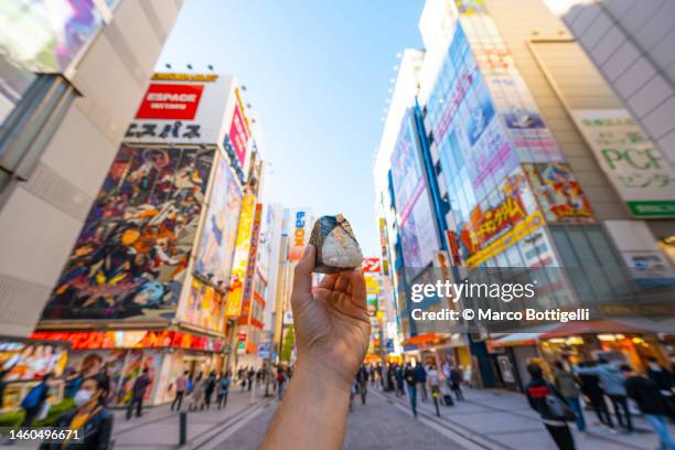 personal perspective of person eating onigiri in tokyo, japan - tokyo food stock pictures, royalty-free photos & images