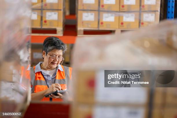 traceability and quality control help to manage recalls and returns. high-angle view of a senior warehouse manager using a digital tablet while working in a distribution warehouse. - produktrückruf stock-fotos und bilder