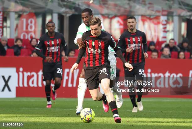 Alexis Saelemaekers of AC Milan is tackled during the Serie A match between AC MIlan and US Sassuolo at Stadio Giuseppe Meazza on January 29, 2023 in...