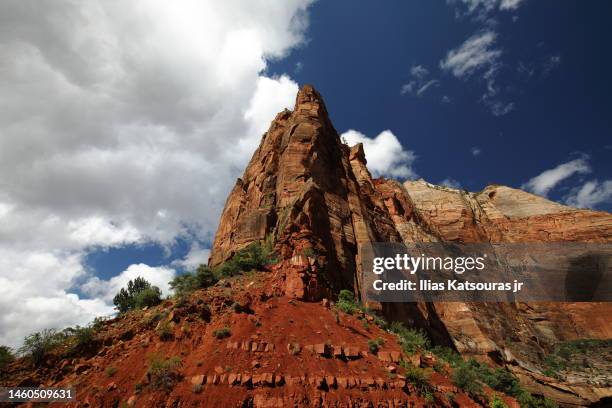 steep rock formation under cloudy sky - rock strata photos et images de collection