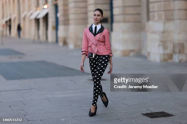 Sabina Jakubowicz seen wearing rose leather jacket, Chanel crossbody micro bag, black pants with white dots print, white flannel and black tie before...