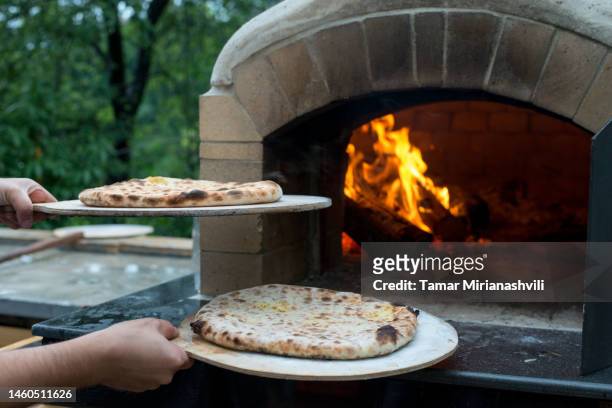 baking khachapuri in a wood burning oven - pizzaugn bildbanksfoton och bilder