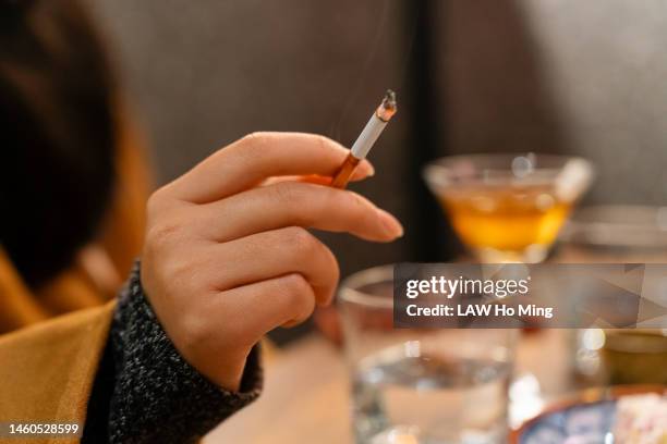 a woman smoking in a tavern - tobacco product imagens e fotografias de stock