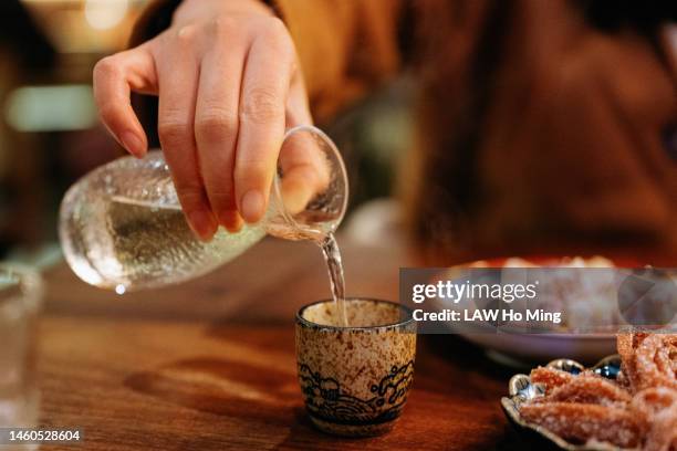 pouring japanese sake - sake stock pictures, royalty-free photos & images