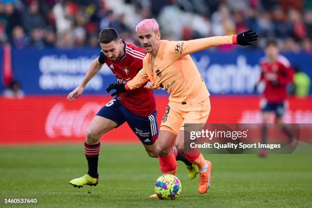 Moises Gomez of CA Osasuna compete for the ball with Antoine Griezmann of Atletico de Madrid during the LaLiga Santander match between CA Osasuna and...