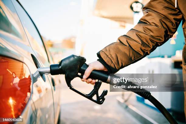 unrecognizable person fueling up in times of energy crisis - price gouging stockfoto's en -beelden