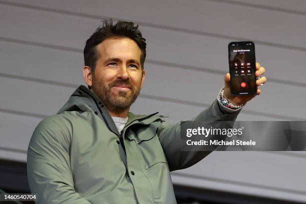 Ryan Reynolds speaks to Rob McElhenney, fellow Co-Owner of Wrexham on the phone during the Emirates FA Cup Fourth Round match between Wrexham and...