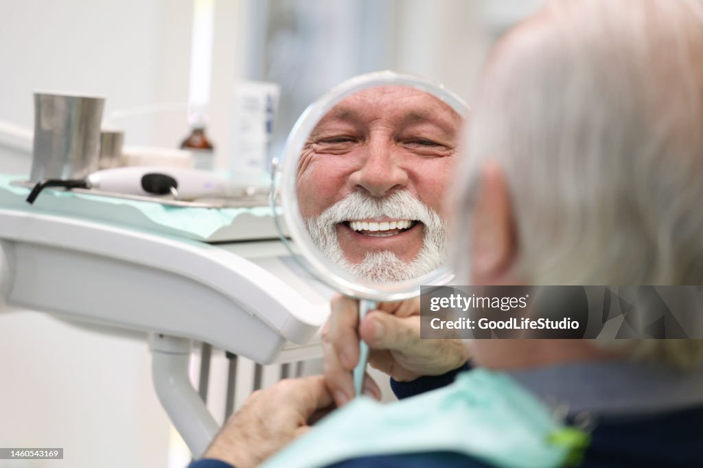 Senior man looking in a mirror at a dentist's office