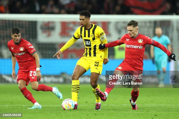 Jude Bellingham of Borussia Dortmund is challenged by Florian Wirtz of Bayer 04 Leverkusen during the Bundesliga match between Bayer 04 Leverkusen...