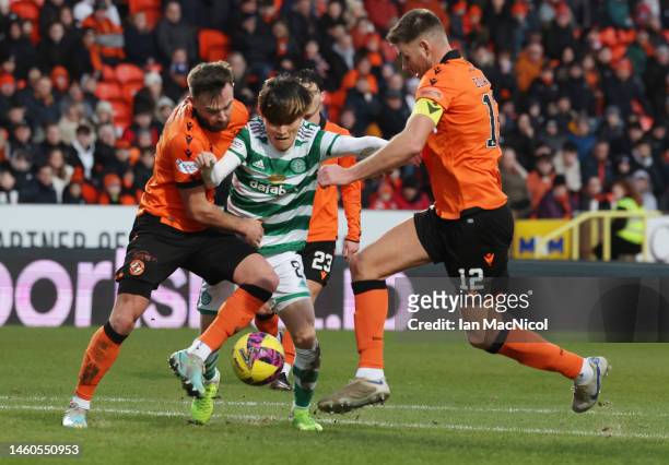 Kyogo Furuhashi of Celtic vies with Scott McMann and Ryan Edwards of Dundee United during the Cinch Scottish Premiership match between Dundee United...