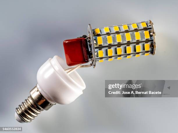 detail of the parts of a disassembled led bulb against white background - broken light bulb stock pictures, royalty-free photos & images