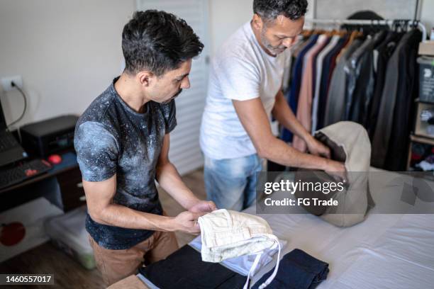 gay couple packing clothes in the bedroom at home - possession stock pictures, royalty-free photos & images