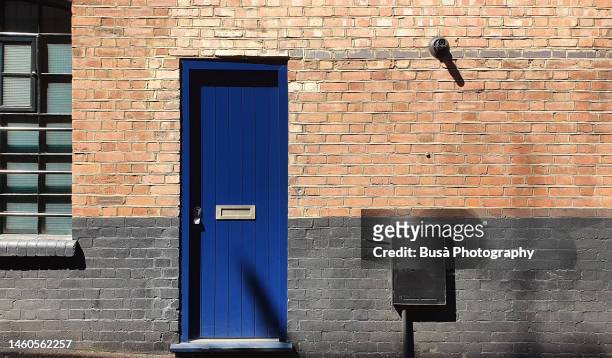 closeup of brick wall with blue door - apartment front door foto e immagini stock