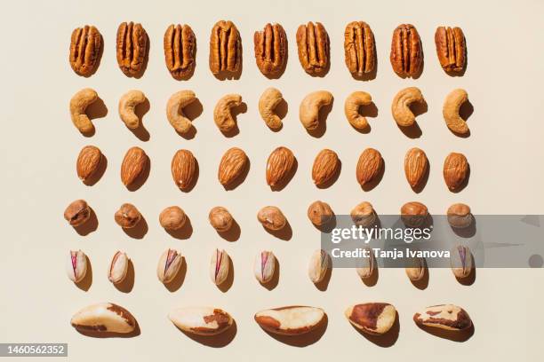 pattern of various nuts on beige. healthy eating concept. pecan, brazil nut, almonds, hazelnuts, pistachios, cashews. top view, flat lay. - almonds isolated stock pictures, royalty-free photos & images