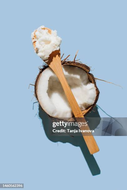ripe coconuts, coconut oil on blue background. health and wellness concept. minimal flat lay style. top view. - huile de coco photos et images de collection