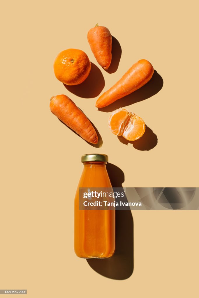 Colorful smoothie or juice bottle beverage drink with various fresh ingredients: fruits and vegetables on beige background. Superfoods, healthy food, drinks, diet and detox concept. Flat lay, top view