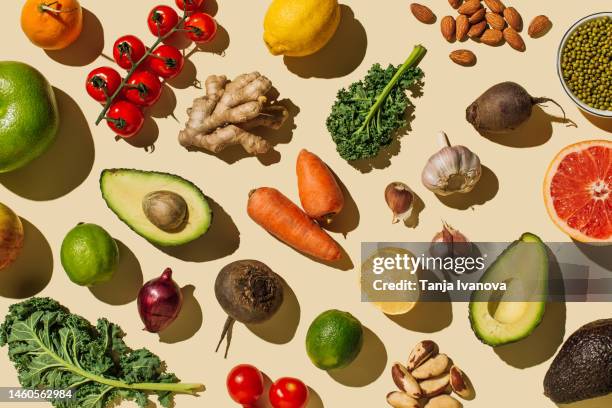 pattern of variety fresh of organic fruits and vegetables and healthy vegan meal ingredients on beige background. healthy food, clean eating, diet and detox, eco friendly, no plastic concept . flat lay, top view - équilibre alimentaire photos et images de collection