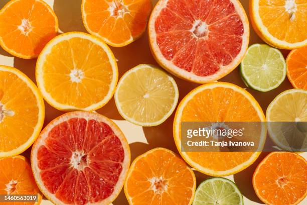 pattern of slices citrus-fruit of lemons, oranges, grapefruit, lime on beige background. healthy food, diet and detox concept. flat lay, top view - citrus fruit stockfoto's en -beelden